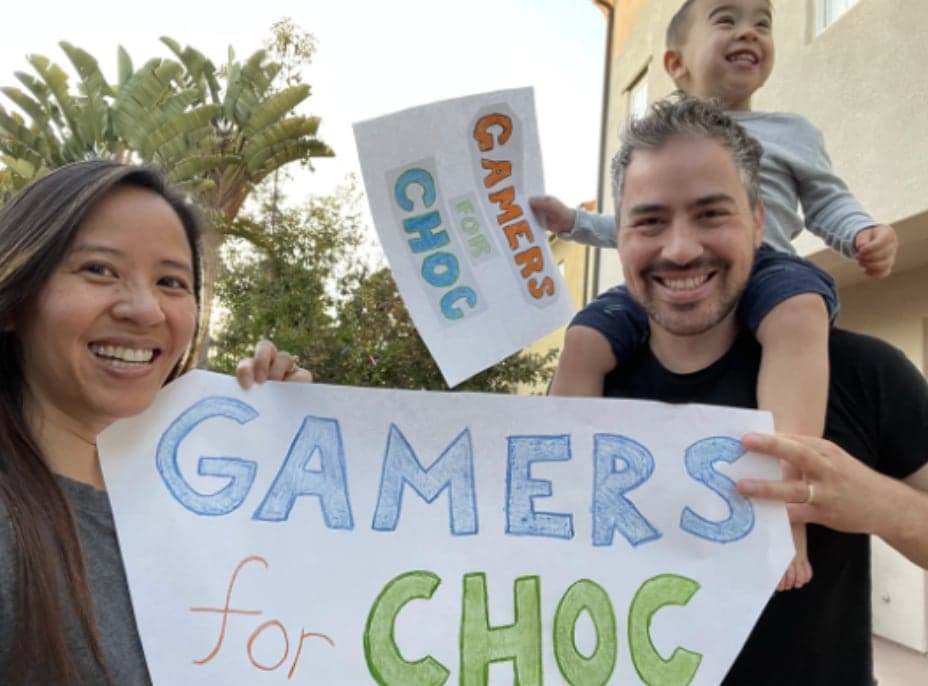 A family holding a Gamers for CHOC sign